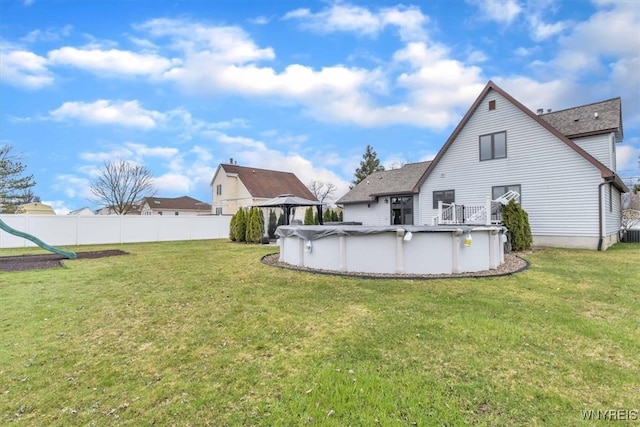 back of house featuring a fenced in pool, a gazebo, a yard, fence, and a playground