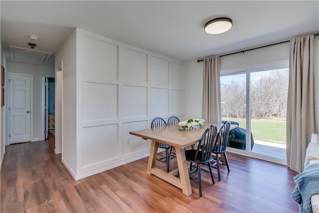 dining room featuring wood finished floors and attic access