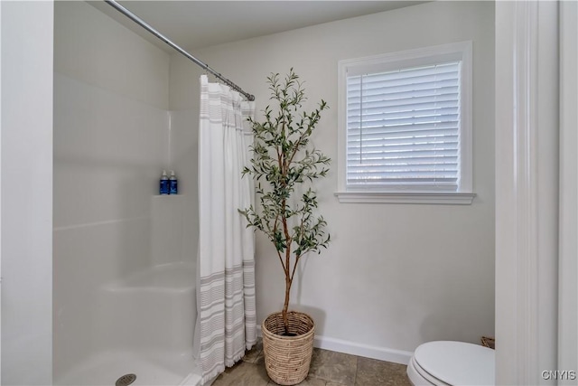 full bathroom featuring toilet, a shower with curtain, and baseboards