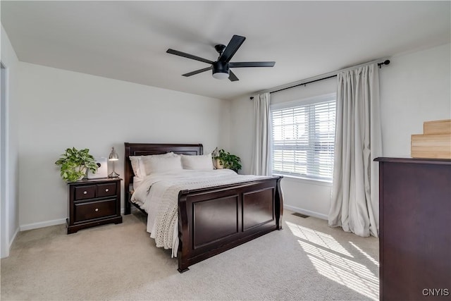 bedroom featuring visible vents, baseboards, a ceiling fan, and light carpet
