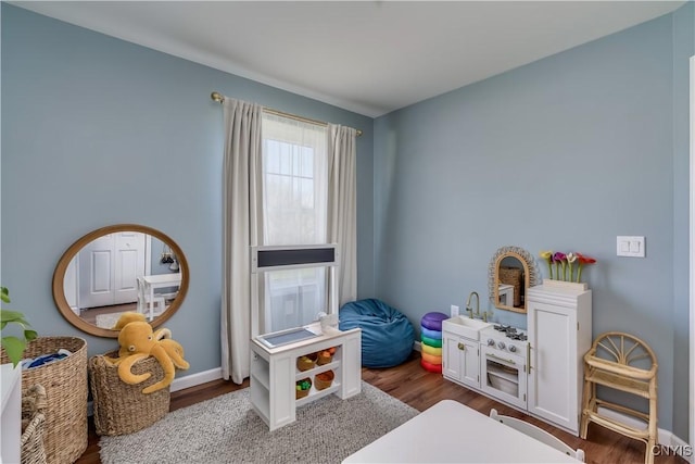 playroom with dark wood-style flooring and baseboards