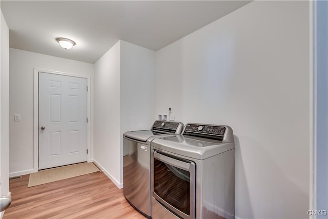 laundry room featuring visible vents, baseboards, light wood-type flooring, laundry area, and independent washer and dryer