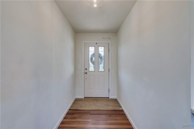 doorway to outside with baseboards and wood finished floors