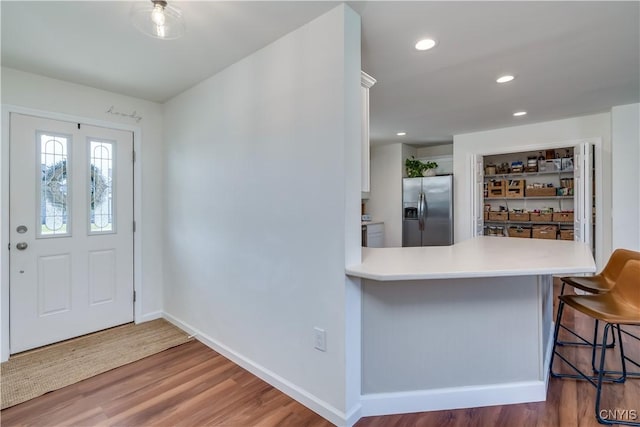 foyer featuring baseboards, recessed lighting, and wood finished floors