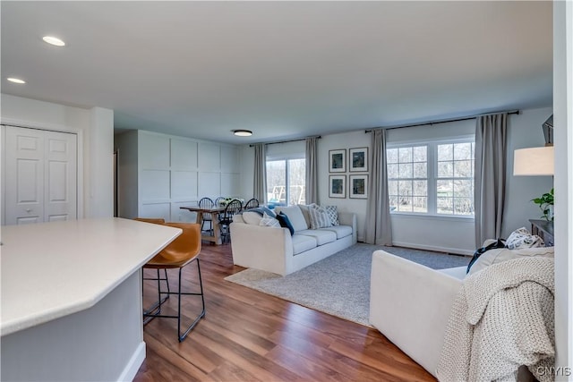 living room with recessed lighting, baseboards, and wood finished floors