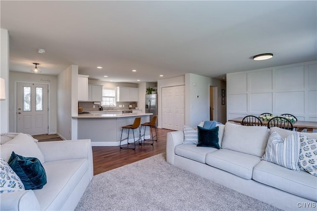 living room with recessed lighting, dark wood-style flooring, and dark carpet
