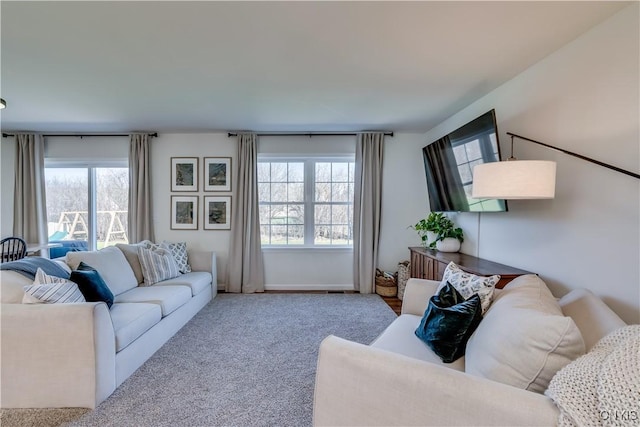 carpeted living area with baseboards