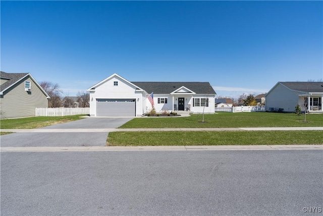 ranch-style house featuring a front yard, driveway, fence, and an attached garage