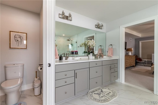 full bath with marble finish floors, toilet, double vanity, a stall shower, and baseboards