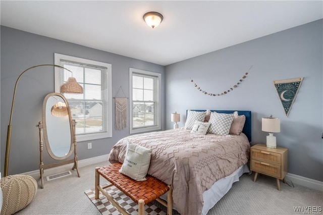 bedroom with light colored carpet and baseboards