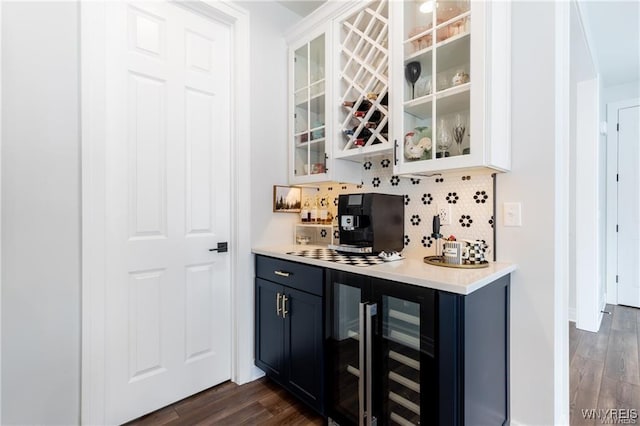 indoor dry bar with wine cooler, decorative backsplash, and dark wood-style floors