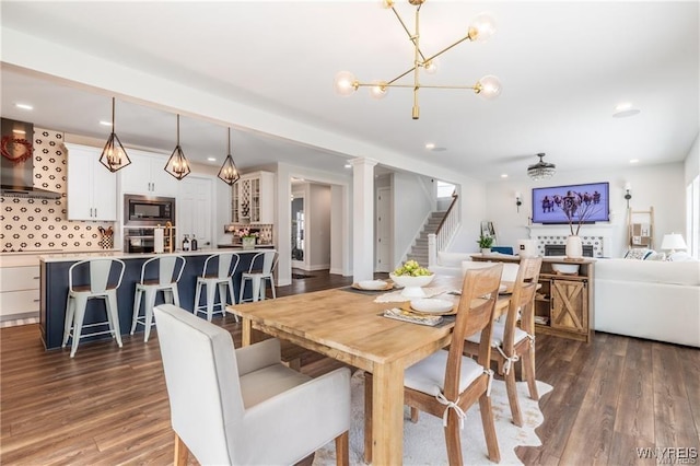 dining room with stairway, dark wood-type flooring, a fireplace, a chandelier, and recessed lighting