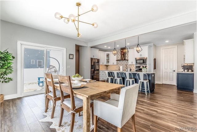 dining space featuring a chandelier, dark wood-type flooring, baseboards, and recessed lighting