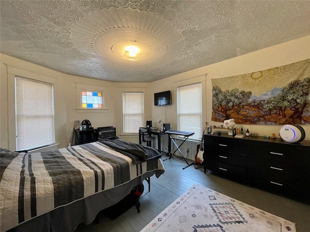 bedroom featuring a textured ceiling and wood-type flooring
