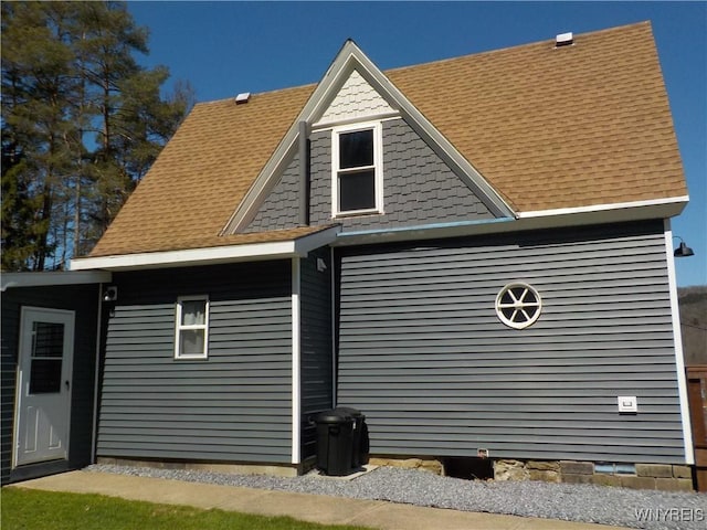view of side of home featuring roof with shingles