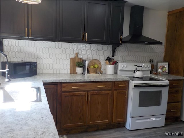 kitchen featuring black microwave, light countertops, white electric range, wall chimney exhaust hood, and decorative backsplash