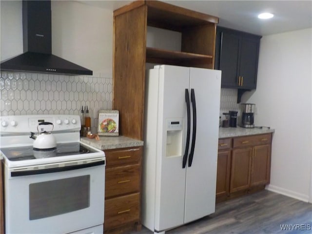 kitchen featuring backsplash, wall chimney exhaust hood, white appliances, light countertops, and dark wood-style floors