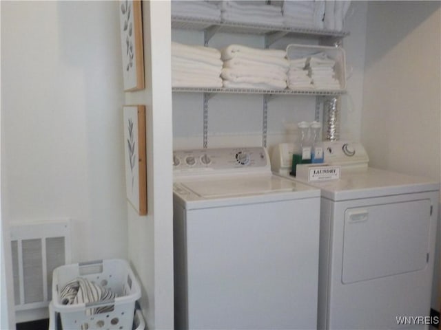 washroom with visible vents and separate washer and dryer