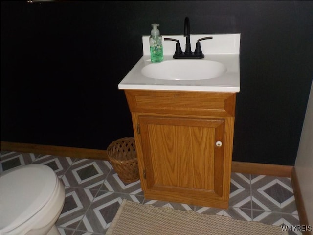 bathroom with vanity, baseboards, and toilet