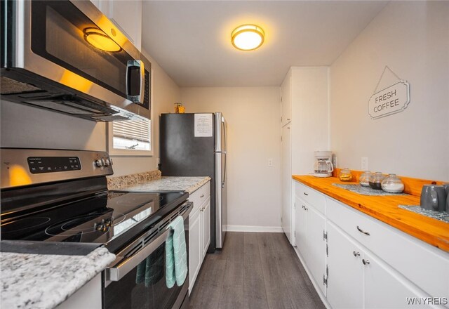 523 76th St, Niagara Falls, NY 14304 - kitchen featuring dark wood-style flooring, appliances with stainless steel finishes, white cabinetry, baseboards, and butcher block countertops