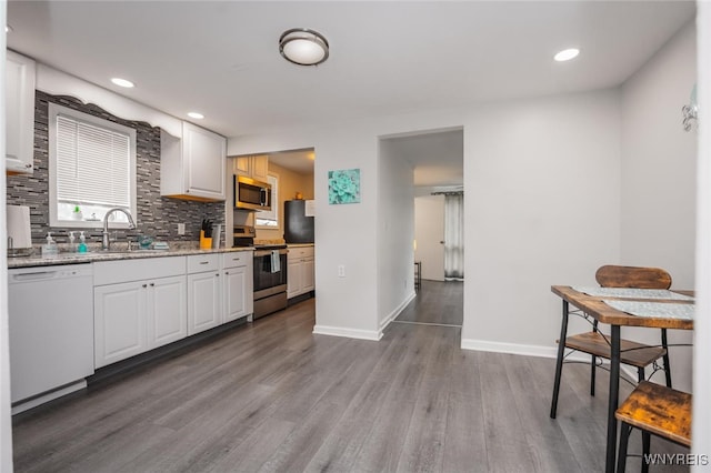 523 76th St, Niagara Falls, NY 14304 - kitchen with tasteful backsplash, wood finished floors, a sink, white cabinets, and stainless steel appliances