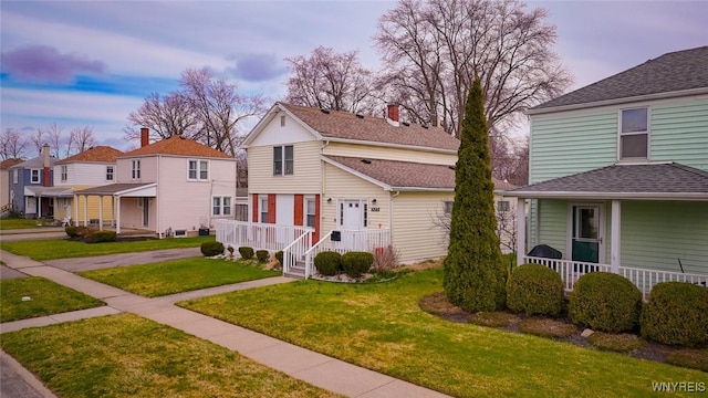 523 76th St, Niagara Falls, NY 14304 - view of front of house with a porch, a residential view, and a front yard