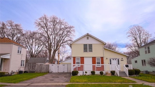 523 76th St, Niagara Falls, NY 14304 - traditional home featuring board and batten siding, a gate, brick siding, cooling unit, and a front lawn