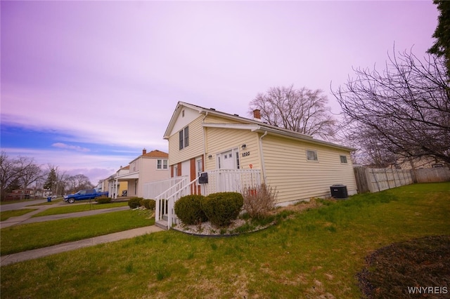 523 76th St, Niagara Falls, NY 14304 - property exterior at dusk featuring fence, central AC unit, and a yard