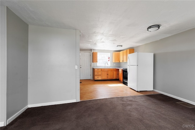 15-17A Vincent St, Champion, NY 13619 - kitchen featuring light colored carpet, freestanding refrigerator, baseboards, and black range with electric cooktop