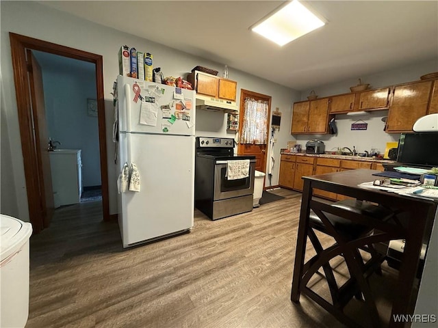 42 Mechanic St, Collins, NY 14070 - kitchen with freestanding refrigerator, electric range, brown cabinets, and light wood finished floors