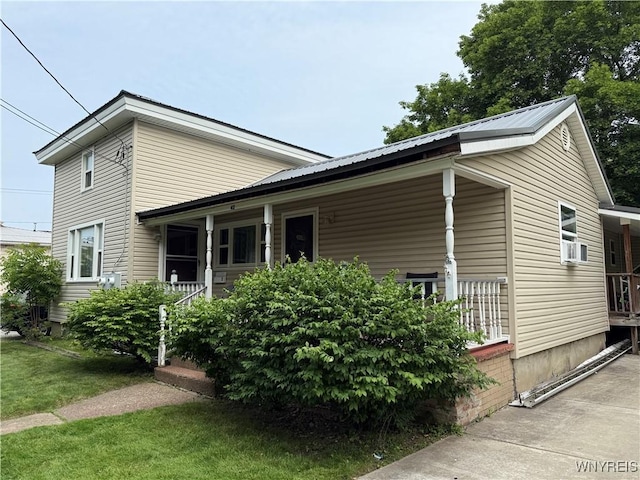 42 Mechanic St, Collins, NY 14070 - view of property exterior featuring a porch, a metal roof, a lawn, and cooling unit