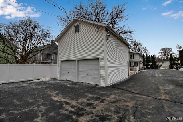 garage featuring fence and driveway