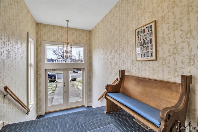 interior space with an inviting chandelier, wallpapered walls, visible vents, carpet flooring, and french doors