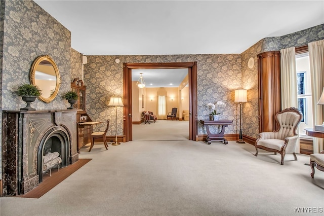 sitting room with baseboards, carpet flooring, and wallpapered walls