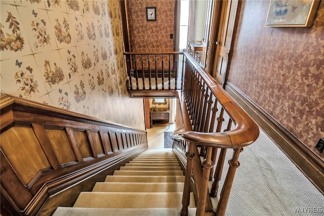 stairway featuring wallpapered walls