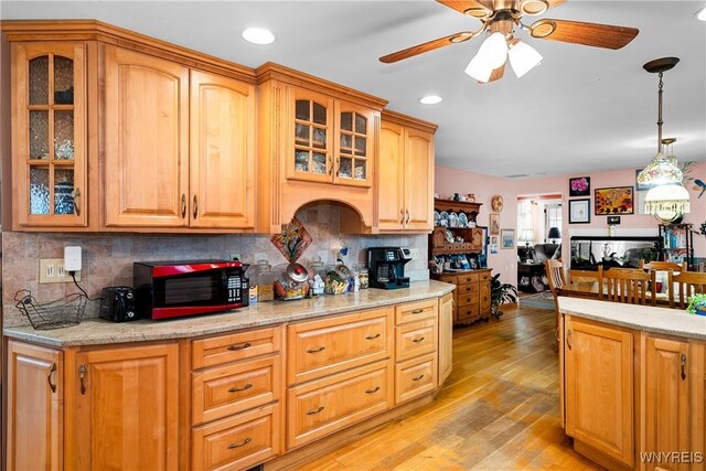 11400 Savage Rd, Sardinia, NY 14030 - kitchen with black microwave, ceiling fan, light wood-style flooring, backsplash, and decorative light fixtures
