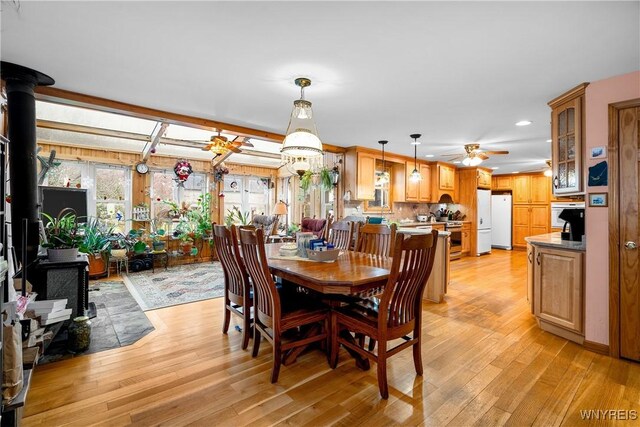11400 Savage Rd, Sardinia, NY 14030 - dining space featuring light wood-style flooring, ceiling fan, recessed lighting, and a wood stove