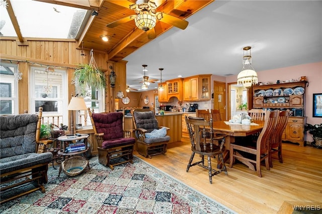 11400 Savage Rd, Sardinia, NY 14030 - dining space with ceiling fan, light wood-style flooring, a skylight, and wooden walls