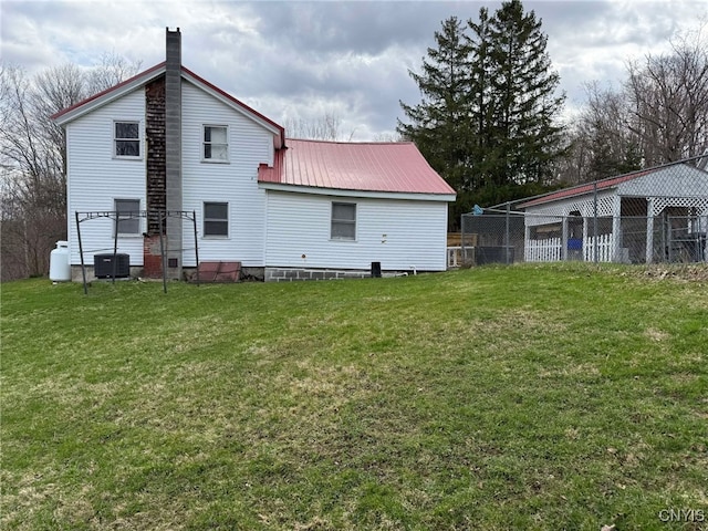 525 Bell Hill Rd, German Flatts, NY 13357 - rear view of property with a chimney, metal roof, fence, and a lawn