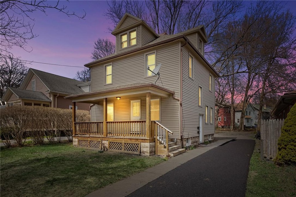 view of front of property featuring covered porch and a lawn