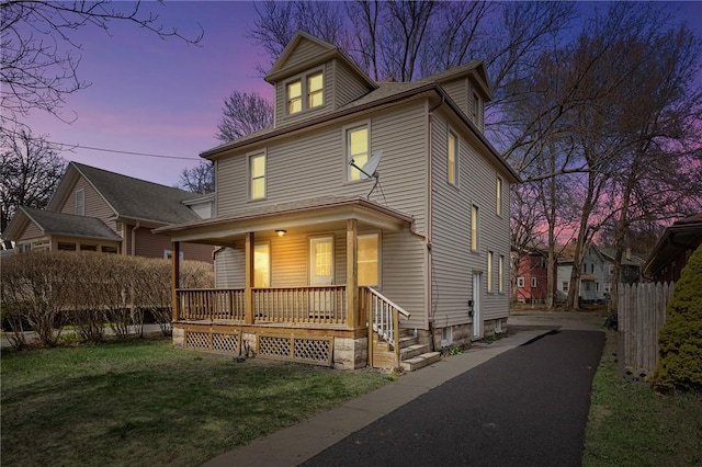 view of front of property featuring covered porch and a lawn