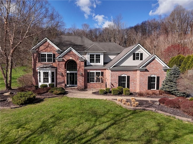 view of front of property with a front lawn and brick siding