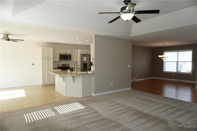 4828 Lighthouse Village Cir, Clay, NY 13088 - unfurnished living room with a sink, ceiling fan with notable chandelier, and baseboards