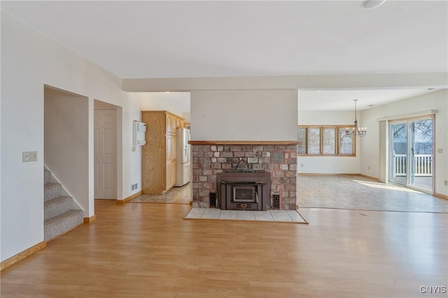 28 Wedgeworth Dr, West Monroe, NY 13167 - unfurnished living room featuring light wood-type flooring, baseboards, a chandelier, and stairway