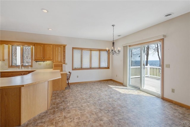 28 Wedgeworth Dr, West Monroe, NY 13167 - kitchen with baseboards, a chandelier, light countertops, decorative light fixtures, and light brown cabinetry