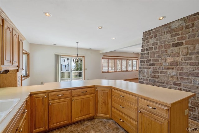 kitchen featuring light countertops, a peninsula, pendant lighting, and recessed lighting