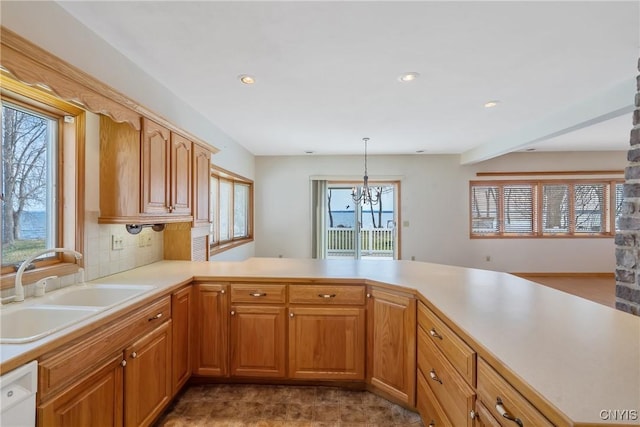 kitchen with recessed lighting, an inviting chandelier, light countertops, dishwasher, and a sink