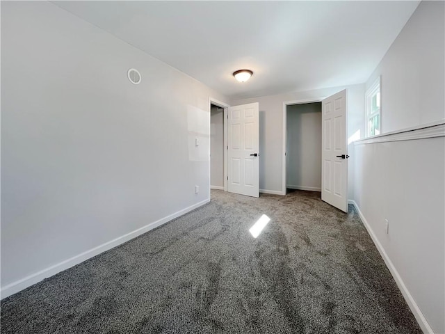 unfurnished bedroom with baseboards and carpet