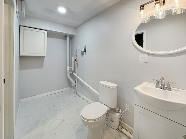 bathroom featuring toilet, marble finish floor, baseboards, and vanity
