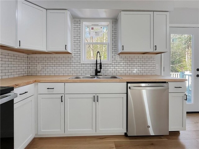kitchen featuring tasteful backsplash, wooden counters, a sink, and appliances with stainless steel finishes